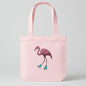 A light pink canvas tote bag featuring a graphic illustration of a pink flamingo wearing turquoise roller skates, set against a plain white background.