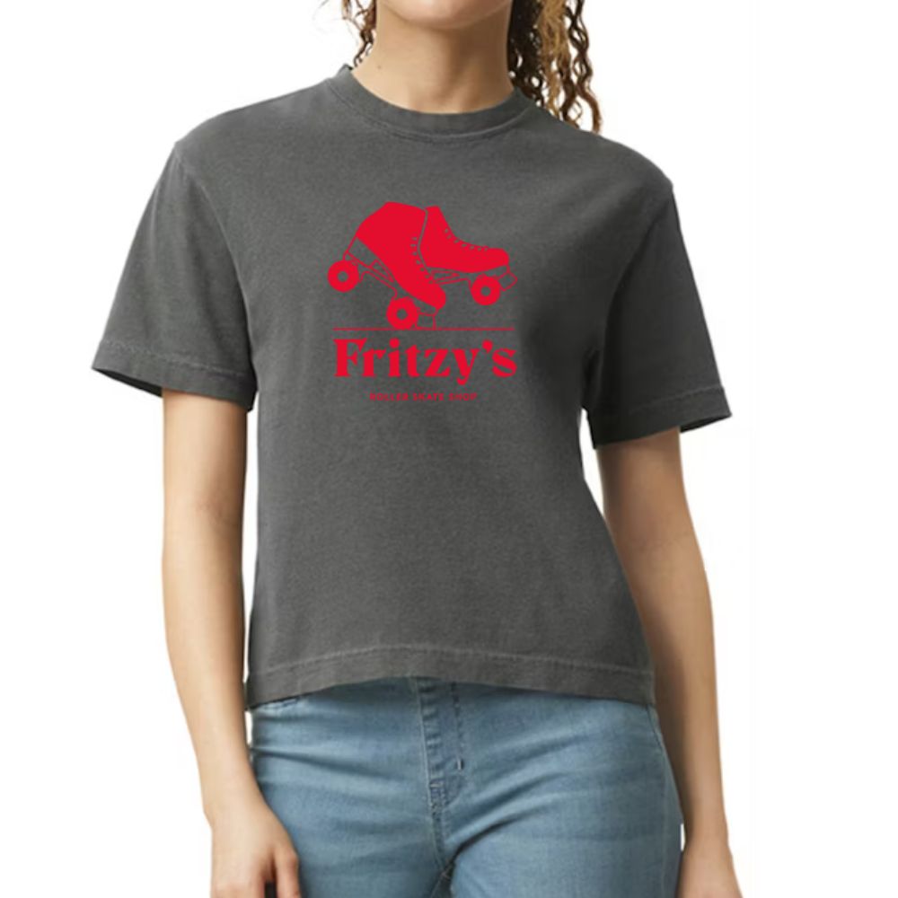 A woman wearing a dark gray heather t-shirt with a red roller skate graphic and the text 'Fritzy's' on the front, paired with blue jeans against a plain white background.