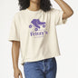 A person wearing a cream-colored short-sleeve t-shirt with a purple roller skate graphic and the text 'Fritzy's Roller Skate Shop' on the front, paired with blue jeans against a plain white background.