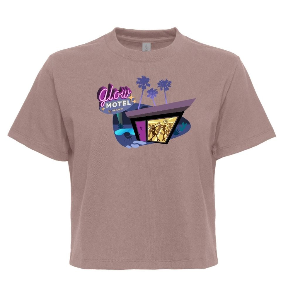 A short-sleeve crewneck t-shirt in a dusty mauve or taupe color, featuring a retro 1960s-style graphic of the 'Glow Motel' with purple palm trees and a neon sign on the chest.